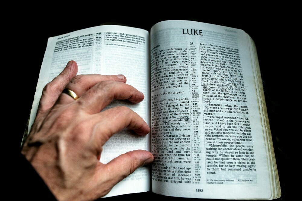 image of an old man reading The Gospel of Luke