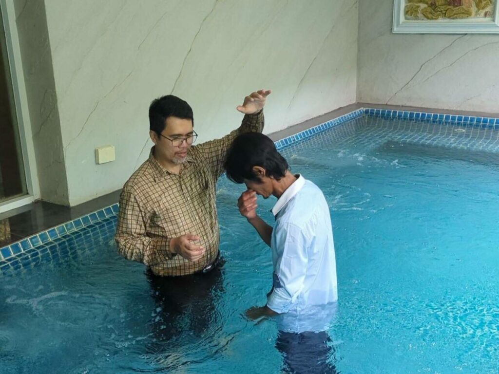 A Testimony of Faith and Healing. Image showing pastor Mark baptizing Khun Nai.
