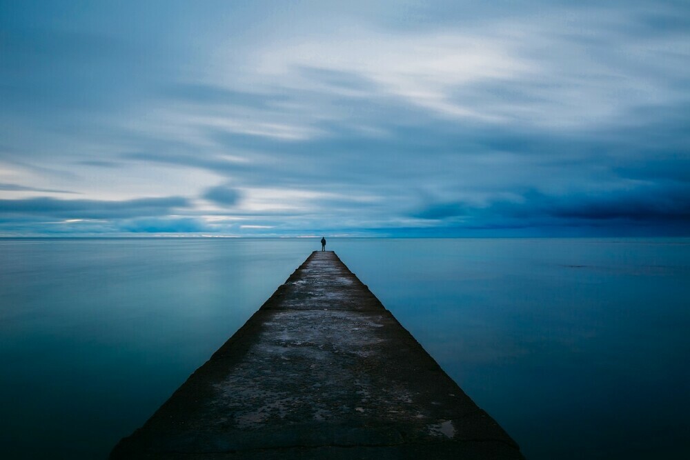 image of a man standing at the pinnacle of the wharf reflecting on his life.