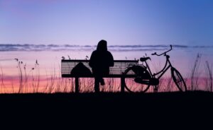 image of a woman with long hair sitting trying to recognize her loneliness.