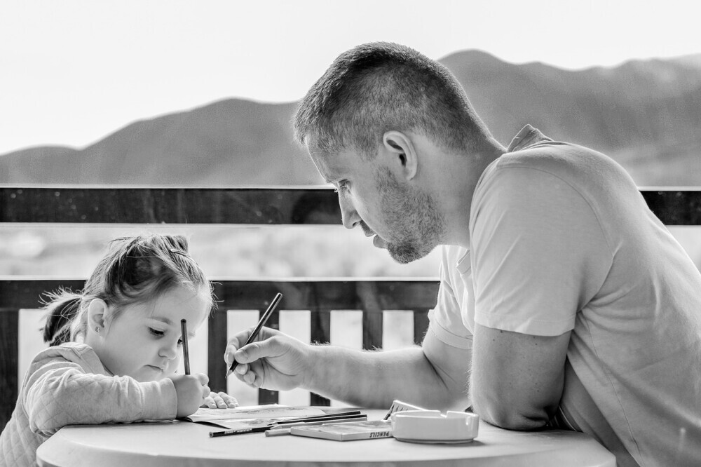 A patient parent assisting their child with homework, showing support and encouraging learning. - Parenting